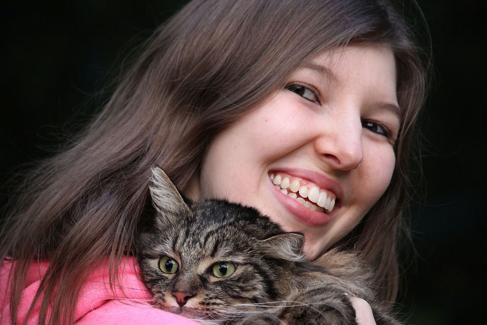 Glückliche Frau umarmt Katze