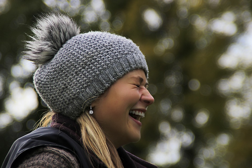 Frau mit Wollmütze erlebt Glücksmoment im Winter