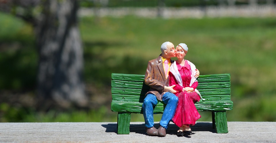 Altes Paar, glücklich auf Parkbank