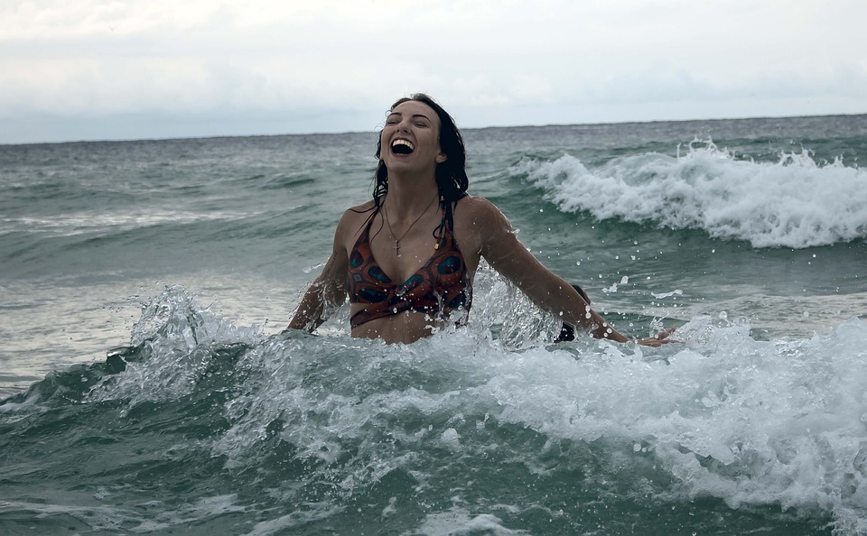 Lebensfreude am Beispiel einer fröhlichen Frau, die im Meer badet